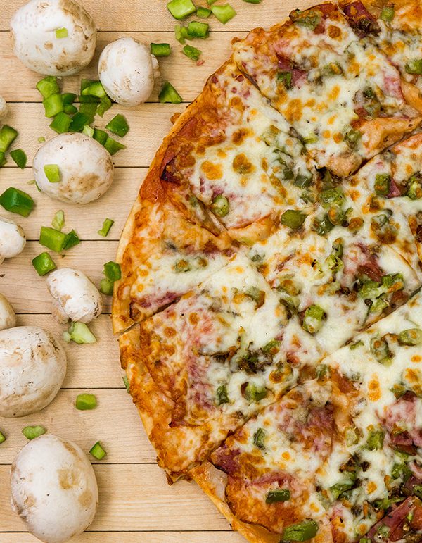 Mushrooms beside a finely-crafted pizza in Steinbach.